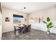 A bright dining room featuring a round wooden table, gray chairs, modern lighting, and neutral decor at 11672 Barga Ct, Las Vegas, NV 89138