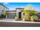 Inviting single-story home with a neutral color palette, desert landscaping and brick driveway, creating a welcoming curb appeal at 11672 Barga Ct, Las Vegas, NV 89138