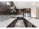 A modern kitchen with a long island featuring dark cabinets, stainless steel appliances, and ample counter space at 11672 Barga Ct, Las Vegas, NV 89138