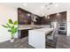 A modern kitchen showcasing dark cabinetry, a mosaic backsplash, a large island, and stainless steel appliances at 11672 Barga Ct, Las Vegas, NV 89138
