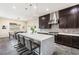Bright kitchen with a long white quartz island, stylish bar stools, dark cabinets, and stainless steel appliances at 11672 Barga Ct, Las Vegas, NV 89138