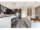 A contemporary kitchen featuring dark wood cabinets, stainless steel appliances, and a large white quartz countertop island at 11672 Barga Ct, Las Vegas, NV 89138