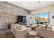 Stylish living room featuring a textured wall, large TV, plush seating, and sliding glass doors to the outdoors at 11672 Barga Ct, Las Vegas, NV 89138