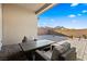 Comfortable outdoor patio area features stone pavers and an outdoor lounge set with mountain views at 11672 Barga Ct, Las Vegas, NV 89138