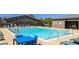 Community pool with clear blue water, surrounded by lounge chairs and tables, perfect for relaxation and recreation at 11672 Barga Ct, Las Vegas, NV 89138