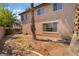 Expansive backyard featuring mature trees, partial home view, and brick walls for privacy at 1220 Padre Serra Ln, Las Vegas, NV 89134