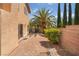 Private backyard patio featuring brick pavers, lush landscaping, and mature palm tree at 1220 Padre Serra Ln, Las Vegas, NV 89134