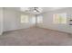 Spacious bedroom featuring neutral carpet, a ceiling fan, and multiple windows at 1220 Padre Serra Ln, Las Vegas, NV 89134