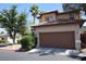 Two-story home featuring a large garage, desert landscaping, and a tile roof in a residential area at 1220 Padre Serra Ln, Las Vegas, NV 89134