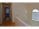 Hallway with wood floors, white walls, arched window with blinds, and access to other rooms at 1220 Padre Serra Ln, Las Vegas, NV 89134