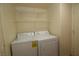 Laundry room includes a white washer and dryer with shelving at 1220 Padre Serra Ln, Las Vegas, NV 89134