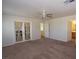 Main bedroom featuring carpet, ceiling fan, and doors to the attached bathroom at 1220 Padre Serra Ln, Las Vegas, NV 89134