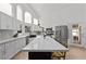 Modern kitchen with white cabinets, marble countertops, stainless steel appliances, and island with seating at 15 Pheasant Ridge Dr, Henderson, NV 89014