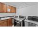 Well-equipped laundry room with cabinetry, sink, workspace, and stainless steel washer and dryer at 15 Pheasant Ridge Dr, Henderson, NV 89014