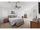 Spacious bedroom with neutral carpet, ceiling fan, side tables and arched window with plantation shutters at 15 Pheasant Ridge Dr, Henderson, NV 89014