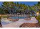 Private backyard pool surrounded by mature trees and well-maintained landscaping at 15 Pheasant Ridge Dr, Henderson, NV 89014