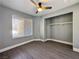 Bright bedroom with dark woodgrain flooring, ceiling fan and open closet at 1509 Linnbaker Ln # 102, Las Vegas, NV 89110