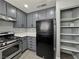 This kitchen has stainless steel appliances, grey cabinets, and a convenient pantry closet at 1509 Linnbaker Ln # 102, Las Vegas, NV 89110