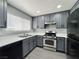 Modern kitchen with gray cabinets, stainless steel appliances, and a bright window at 1509 Linnbaker Ln # 102, Las Vegas, NV 89110