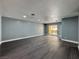 Open living room with gray walls, LVP floors and a sliding glass door to the outside at 1509 Linnbaker Ln # 102, Las Vegas, NV 89110