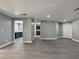Bright living room with gray vinyl flooring and a view to the kitchen with stainless steel appliances at 1509 Linnbaker Ln # 102, Las Vegas, NV 89110
