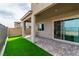 Backyard featuring a covered patio, artificial turf and sliding glass doors at 1596 Pacific Baza St, Las Vegas, NV 89138