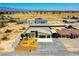 Wide aerial view of a beige house that features a two-car garage, metal awning, and desert landscaping at 1801 S Manzanita Dr, Pahrump, NV 89048