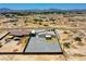 Aerial view of a single Gathering home on a desert property with a metal awning and fenced yard at 1801 S Manzanita Dr, Pahrump, NV 89048