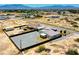 Aerial view of a modern desert home featuring a metal awning, desert landscaping, and perimeter fencing at 1801 S Manzanita Dr, Pahrump, NV 89048