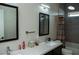 Bathroom featuring dual sinks, mirrors, modern fixtures, and a shower-tub combination at 1801 S Manzanita Dr, Pahrump, NV 89048
