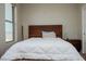 Cozy bedroom featuring a wood-framed bed, warm lighting, and a view out of a large window at 1801 S Manzanita Dr, Pahrump, NV 89048