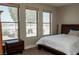 Comfortable bedroom features a wood frame bed and three windows offering bright natural light at 1801 S Manzanita Dr, Pahrump, NV 89048