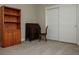 Vacant bedroom with neutral walls, carpet, a vintage desk and shelf, and a closet, offering a versatile space at 1801 S Manzanita Dr, Pahrump, NV 89048