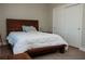 This is a well-lit bedroom with a wood frame bed, a plush white comforter, and sliding closet doors at 1801 S Manzanita Dr, Pahrump, NV 89048