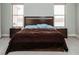 Comfortable bedroom with a wooden bed frame, natural light, and carpeted floor at 1801 S Manzanita Dr, Pahrump, NV 89048
