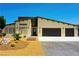 Beautiful single-story home featuring a modern design, three-car garage, and desert landscaping at 1801 S Manzanita Dr, Pahrump, NV 89048