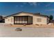 Tan single-story home featuring a gravel yard, rock accents, and a covered patio with window coverings at 1801 S Manzanita Dr, Pahrump, NV 89048