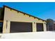 Spacious three-car garage with dark brown doors and a concrete driveway at 1801 S Manzanita Dr, Pahrump, NV 89048