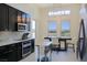 A contemporary kitchen features stainless appliances, dark cabinets, and eat-in kitchen table at 1801 S Manzanita Dr, Pahrump, NV 89048