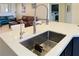 Modern kitchen sink with stainless steel faucet and white countertop overlooks the living area at 1801 S Manzanita Dr, Pahrump, NV 89048