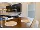 Eat-in kitchen featuring a wooden table and sleek dark cabinetry with modern appliances at 1801 S Manzanita Dr, Pahrump, NV 89048