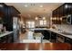 Open kitchen boasts dark cabinetry, stainless appliances, island, and flows into an open floor plan at 1801 S Manzanita Dr, Pahrump, NV 89048