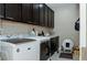 Functional laundry room features modern washer and dryer, sleek dark cabinets, and tiled flooring at 1801 S Manzanita Dr, Pahrump, NV 89048