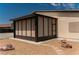 Enclosed tan-colored patio with decorative rock, a tile walkway, and a view of the neighbor's house at 1801 S Manzanita Dr, Pahrump, NV 89048