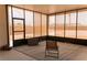 This sunroom features tile flooring, a portable grill, and a chair for enjoying the weather at 1801 S Manzanita Dr, Pahrump, NV 89048