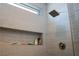 Modern shower with sleek tile, inset shelving, modern shower head, and glass door at 1801 S Manzanita Dr, Pahrump, NV 89048