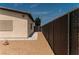 Image shows the side of a home with a chainlink fence and rock landscaping along the perimeter at 1801 S Manzanita Dr, Pahrump, NV 89048