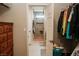 Walk-in closet with dresser leading to bright bathroom with tiled shower and stone pebble floor at 1801 S Manzanita Dr, Pahrump, NV 89048