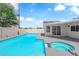 An in-ground pool and spa are surrounded by concrete in this backyard with a gray privacy fence at 1905 E Oakey Blvd, Las Vegas, NV 89104