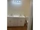 Bathroom with a dual sink vanity with white cabinets and marbled countertops at 1905 Harvard St, North Las Vegas, NV 89030